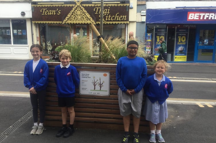 Iman, Frankie, Charlie and Ivy from All Saints March C of E primary school with the winning artwork in Queen Street, Newton Abbot. 