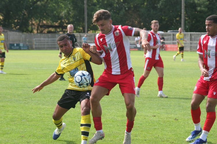 Buckland defender Myles James going shoulder to shoulder vs Newquay AFC