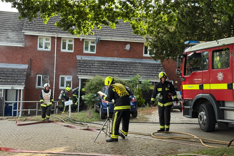 Firefighters in breathing apparatus about to enter the property on fire in Crediton. AQ 7763