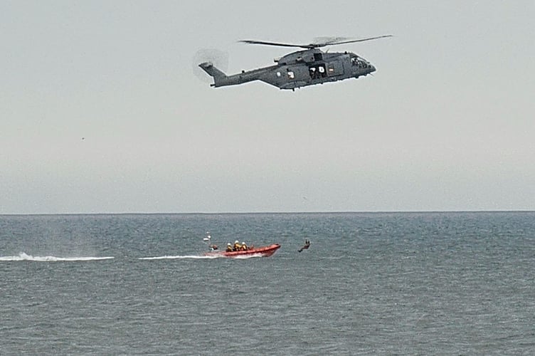 A casualty is winched between the RNAS Yeovilton Merlin helicopter and the Teignmouth lifeboat, Claude and Kath. Photo: Claire Twitchin