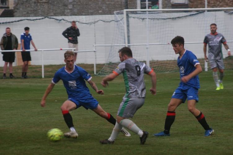 Chris Harvey (left) puts pressure on Bovey Tracey midfielder Cieran Bridger