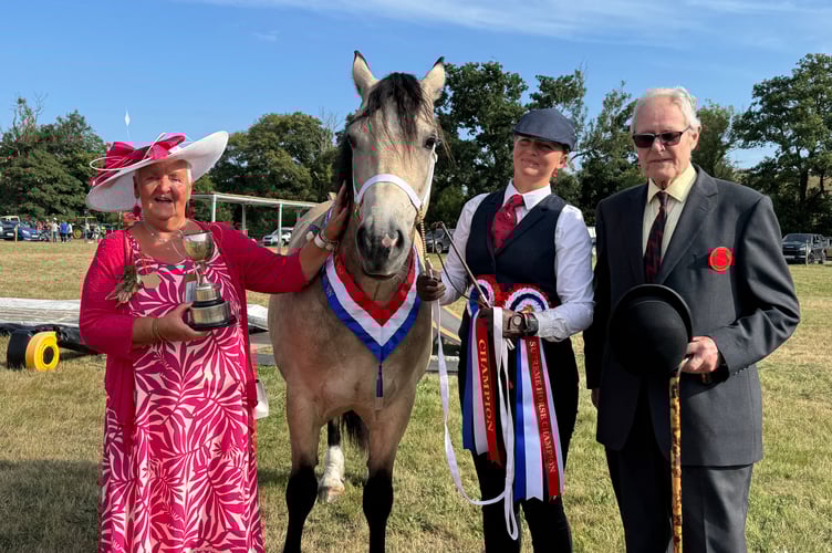 Chagford Show President Pam Shilston presented the Supreme Horse Show trophy to Millie Logan from near Okehampton who won with Penlangrug The Democrat, a 9-year-old Section D, Right is judge, Richard Vine.  AQ 1117
