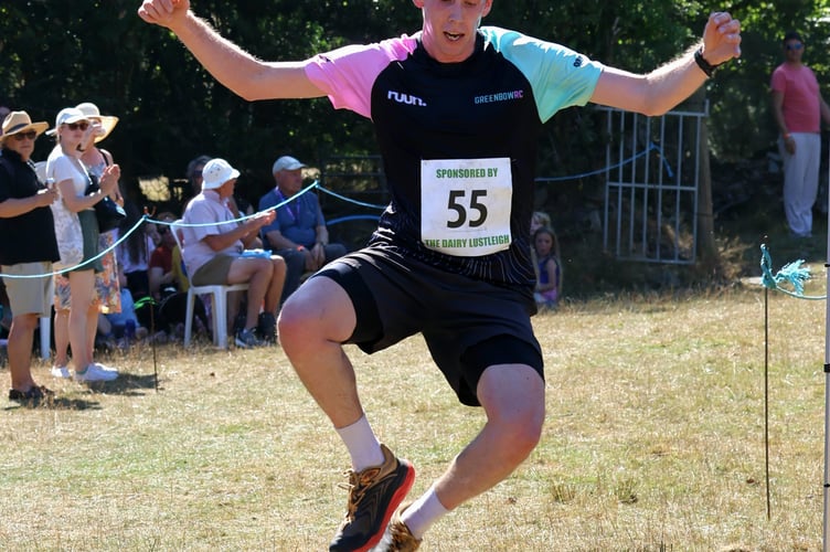 Winner of the 10K Sam Husband leaps across the finish line. Photo: Owain Davies