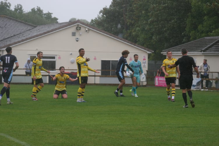 Bemused Buckland players react to a penalty being awarded