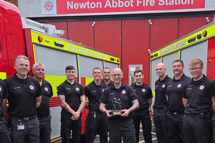 Gary Robinson with Newton Abbot Fire Station colleagues after being presented with his retirement gift of an engraved statue of two firefighters in breathing apparatus