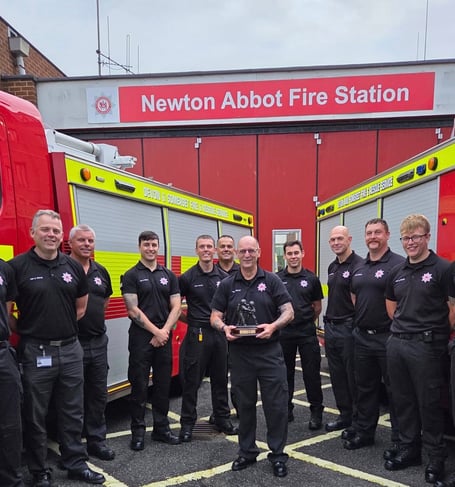 Gary Robinson with Newton Abbot Fire Station colleagues after being presented with his retirement gift of an engraved statue of two firefighters in breathing apparatus