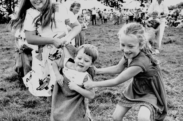 Widecombe Fair from 1987 and Angela Irish, Edward Lamb and Julie Lamb are taking part in the sack race