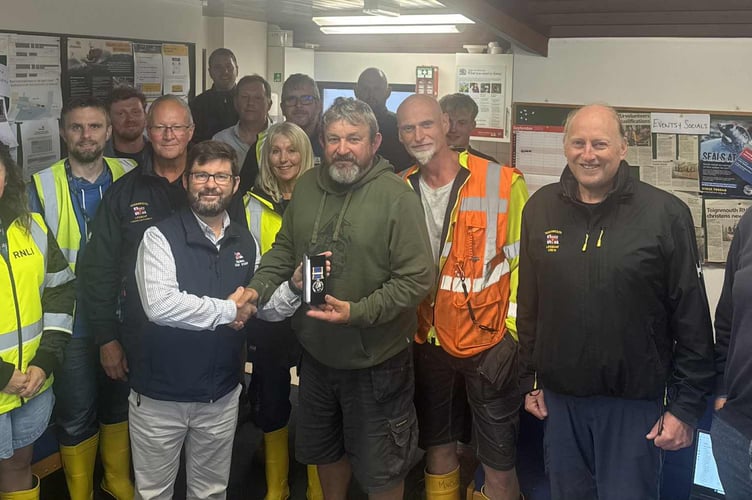 Charlie Woolnough receives his long-service medal in recognition of 30 years of dedication and commitment to RNLI Teignmouth