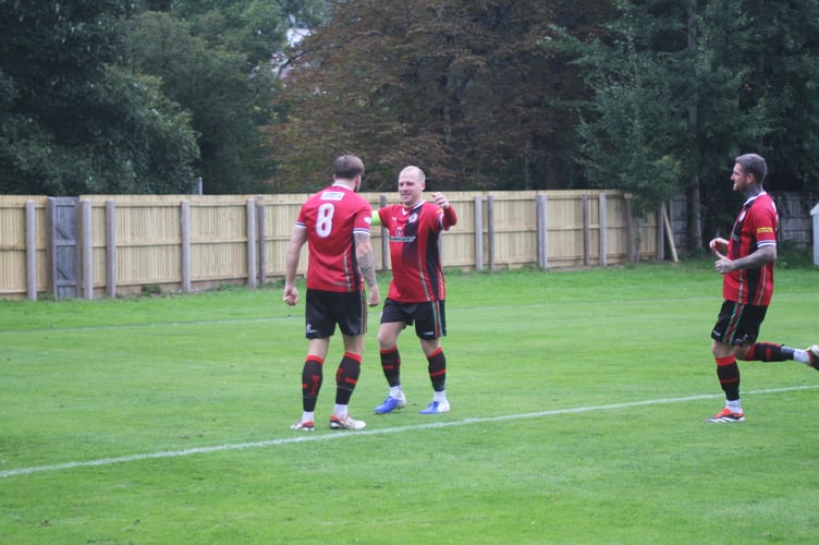 Bovey goalscorer Stockton and captain Perring celebrate
