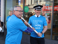 Senior police officer walks with Baton of Hope 