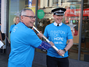 Senior police officer walks with Baton of Hope 