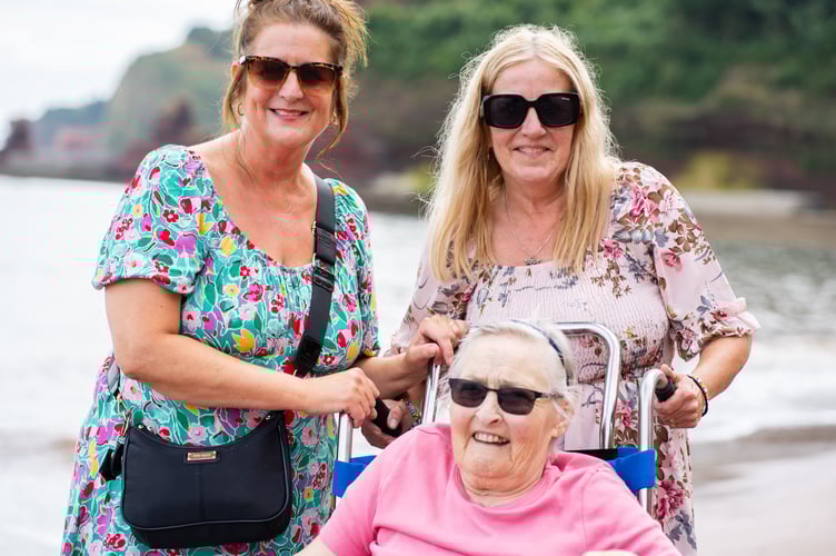 Julie Yates and Lisa Burge from the Sefton Hall care team at the beach in Dawlish with resident Shirley Mapston.