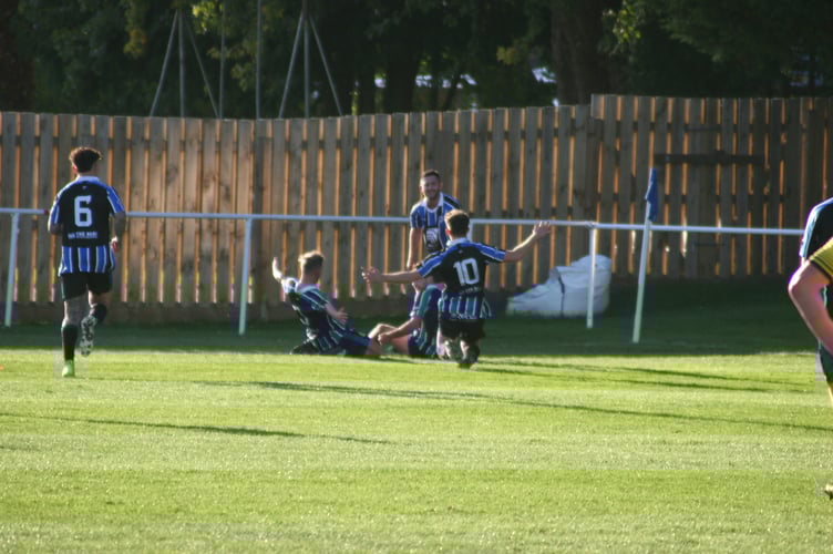 Spurs players sliding into the corner to celebrate