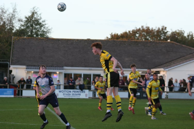 Rafael Beadman heads clear for Buckland Athletic