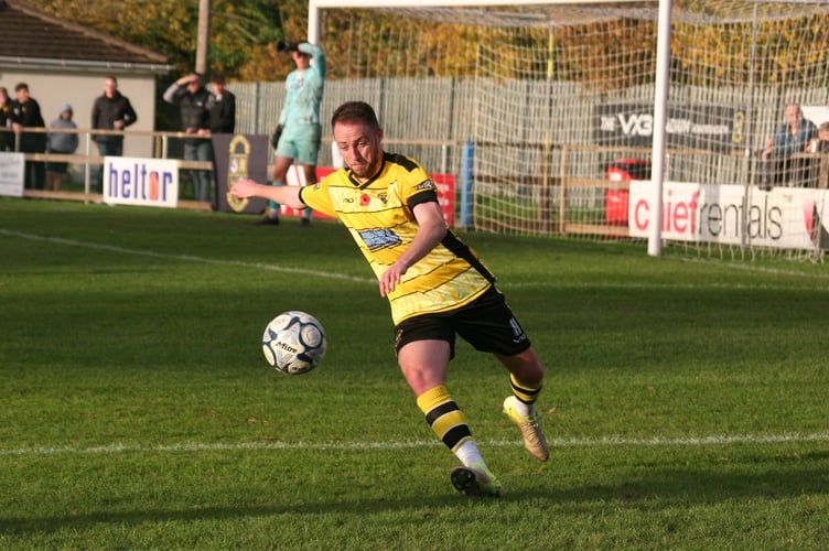 Luke Forward smashes clear for Buckland Athletic