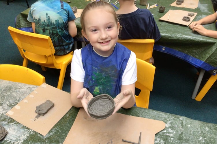 One of the pupils at Teignmouth Primary School shows off her coil pot