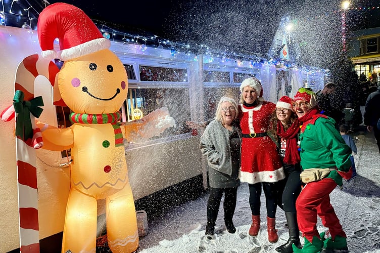 Pictured left to right are Michelle Shorland of Dawlish Bowling Club, Ali Cross of Dawlish Chamber of Trade, Emma Nankervis Music Co-ordinator and Linda Marsh of Dawlish Community Transport standing outside of the Dawlish Gingerbread Cottage under a blizzard of snow.  Photo supplied 