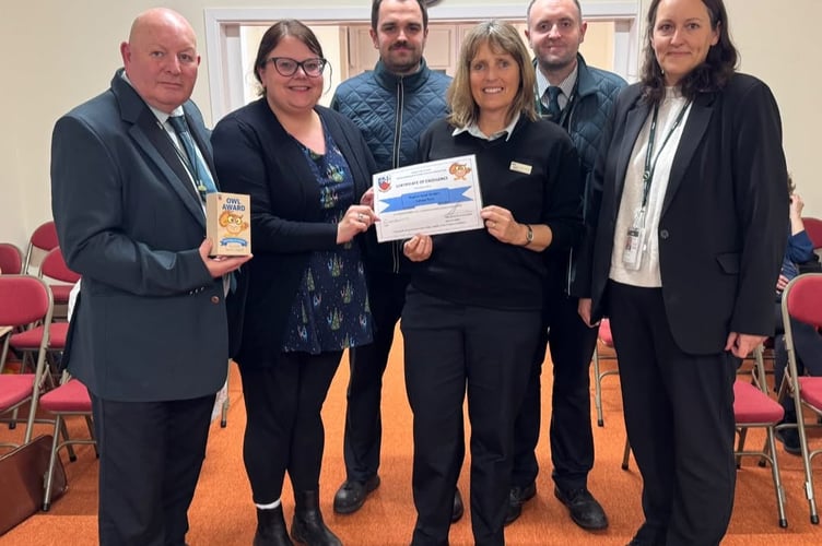 Councillor Rosie Dawson presents staff from Dawlish Railway Station with the OWL award.