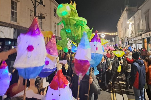 Children proudly carry Christmas lanterns in town parade 