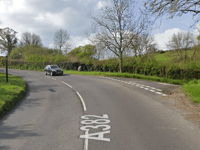 Fallen tree blocks moorland road 
