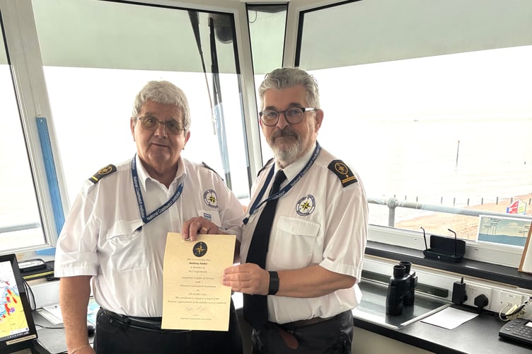 Tony Parker receives his ten year service award from Teignmouth NCI station manager James Campbell.