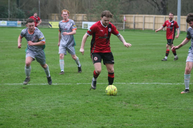 Lively Bovey Tracey midfielder Cal Leech in possession