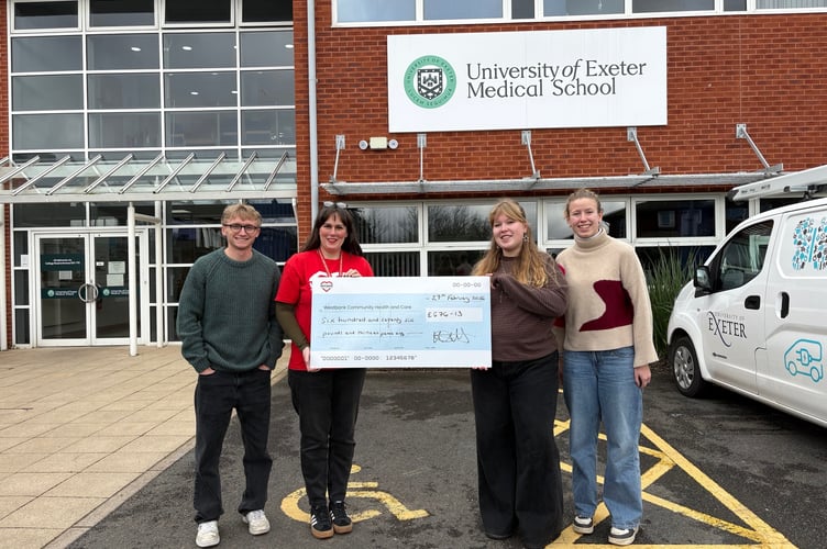 Westbank’s Katie Elliott (in red T) being presented with a cheque by students at Exeter Medical School. 