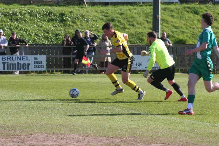 Ryan Bush takes the ball around the Helston keeper