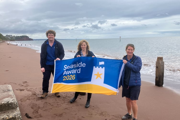 Teignmouth Town Council and district council staff with Seaside Award banner on Teignmouth beach
