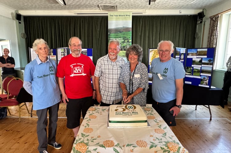 The celebration cake is cut by Sue Viccars, author of the Two Moors Way Guide and Two Moors Way Association Information Officer, with left, Janet Auckland, Colin Piper, Les Bright and right, John Howell, Association members.  AQ 2100
