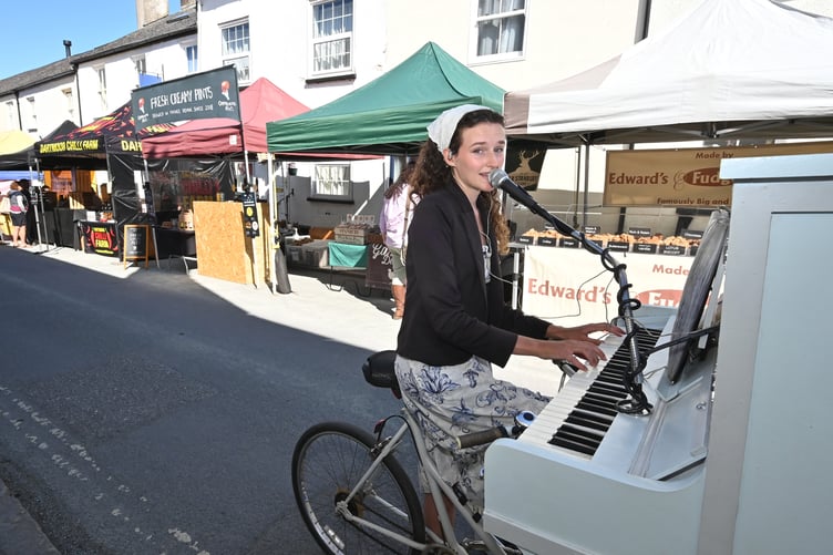 Moretonhampstead Food Festival. If music be the food of life -sing on. Chloe Marie Aston and her piano bike entertain the gastronauts as Moreton's Food Festival
