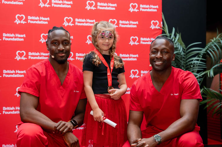 Imogen Newson receiving a Young Heart Hero award from TV presenters Dr Dan Olaiya, left, and Dr Raph Olaiya, right