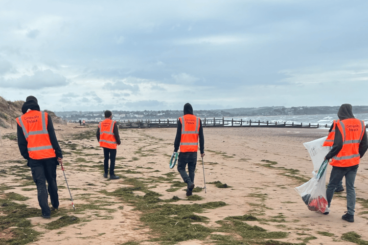 Offenders on Dawlish Warren beach clearing litter as part of unpaid work on community sentences